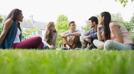 Talking students sitting in gras